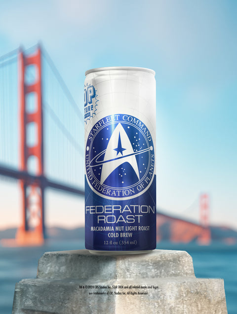 A close-up of a single can of Federation Roast cold brew, showing the detailed artwork of the U.S.S. Enterprise soaring through the stars.