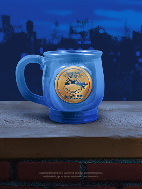 The handthrown stoneware mug for the Teenage Mutant Ninja Turtle, Leonardo, featuring a vibrant blue glaze.