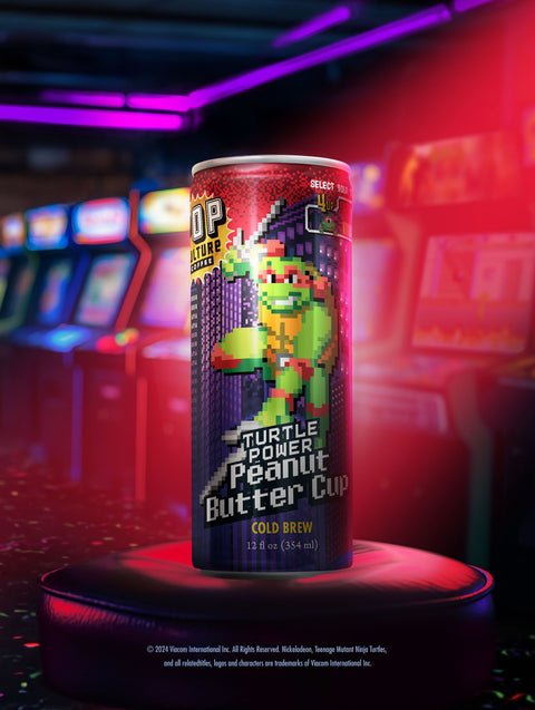 A close-up of a single can showing the retro arcade-style artwork of Raphael holding his twin sai.