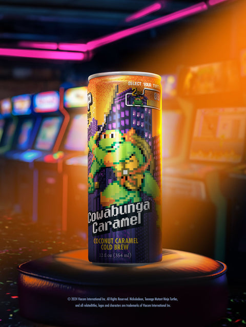 A close-up of a single can showing the retro arcade-style artwork of Michelangelo swinging his nunchucks.