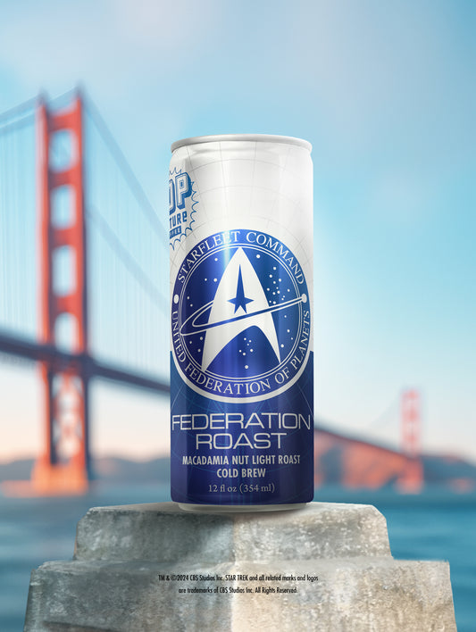 A close-up of a single can of Federation Roast cold brew, showing the detailed artwork of the U.S.S. Enterprise soaring through the stars.