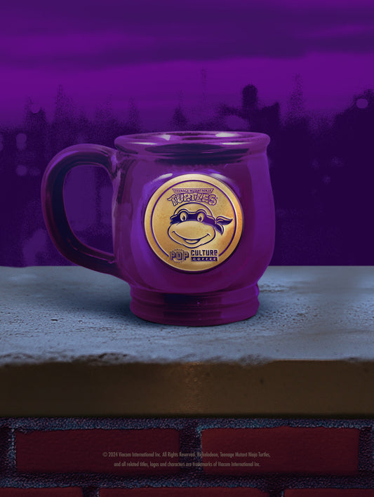 The handthrown stoneware mug for the Teenage Mutant Ninja Turtle, Donatello, featuring a deep purple glaze.