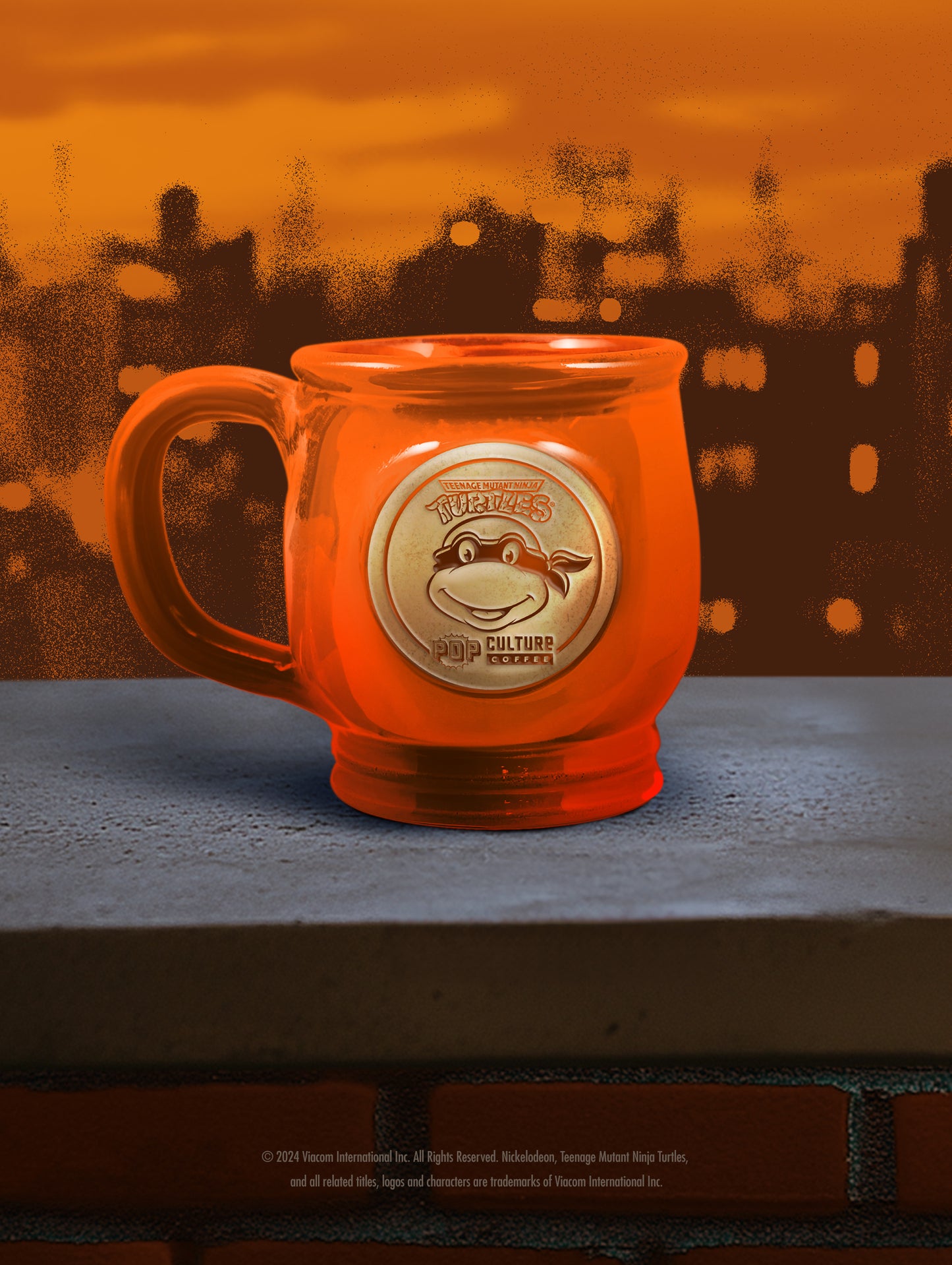 The handthrown stoneware mug for the Teenage Mutant Ninja Turtle, Michelangelo, featuring a vibrant orange glaze.
