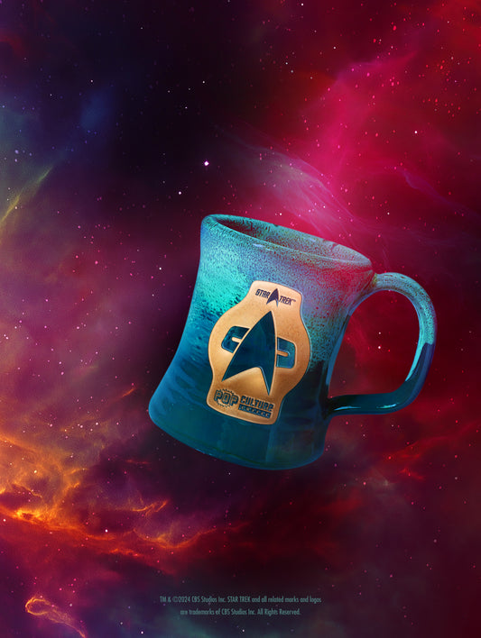 A hand-thrown ceramic mug with a colorful starry space background, featuring the Star Trek Voyager logo.